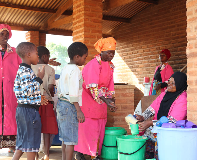 Image of woman handing out food in Malawi